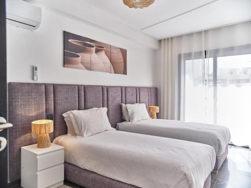 a bedroom with two beds and a large window at TheCasaEdition Gauthier Residency City Center in Casablanca