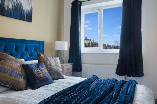 ein Schlafzimmer mit einem blauen Bett und einem Fenster in der Unterkunft Spacious Living Room & Modern Comforts, Sleeps 4 in Peterlee