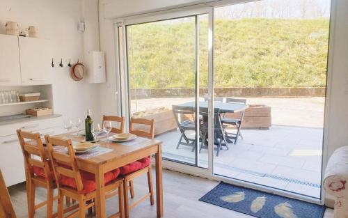 une cuisine et une salle à manger avec une table et des chaises dans l'établissement L'echappee belle 64, à Lasseube