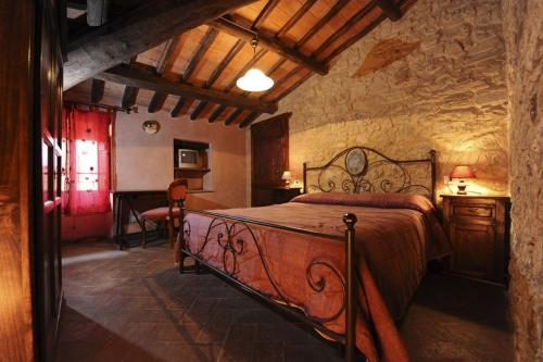 een slaapkamer met een groot bed in een kamer bij Agriturismo L'Elmo in Bagni