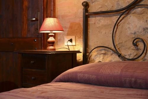 een slaapkamer met een bed met een lamp op een dressoir bij Agriturismo L'Elmo in Bagni