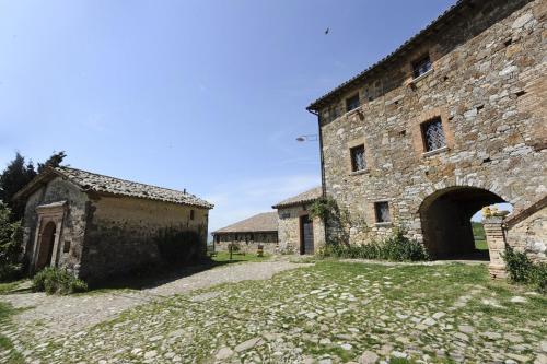 een oud stenen gebouw met een boog in een tuin bij Agriturismo L'Elmo in Bagni