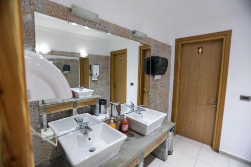 baño con 2 lavabos y espejo grande en Vila Falo, en Voskopojë