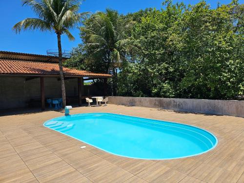 a large blue swimming pool on a wooden patio at HOTEL INDIANO in Rio Bonito