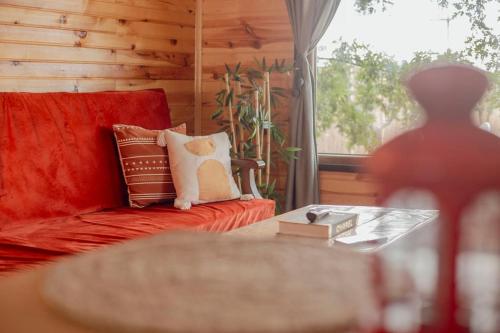sala de estar con sofá rojo y mesa de cristal en Loya Bungalov İznik en İznik