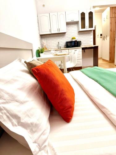 a bed with two orange pillows on it in a kitchen at Orange in Almaty