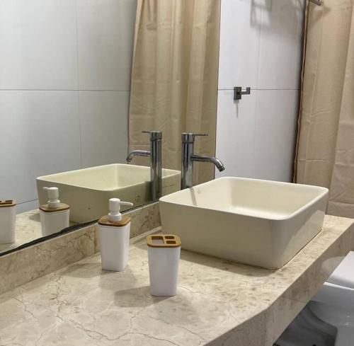 La salle de bains est pourvue d'un lavabo, d'une baignoire et d'un miroir. dans l'établissement Acogedor departamento en el Golf, à Víctor Larco Herrera