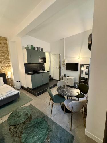 un salon avec un lit, une table et des chaises dans l'établissement Temple Apartments Paris, à Paris