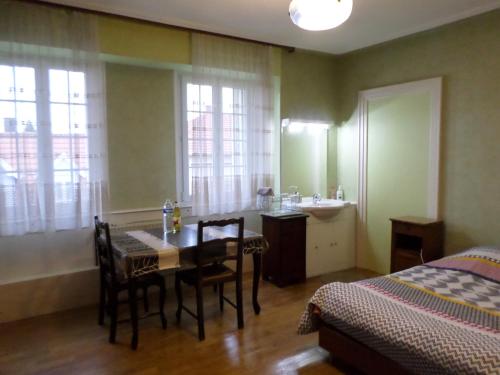 - une chambre avec une table, un lavabo et un lit dans l'établissement Grande chambre individuelle à lit double dans une maison de Maître de 1904, à Haguenau