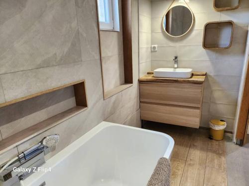 een badkamer met een wit bad en een wastafel bij Petite maison cosy in Hyères