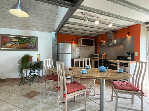 une cuisine avec une table et des chaises dans une pièce dans l'établissement Chez daude, à Précilhon