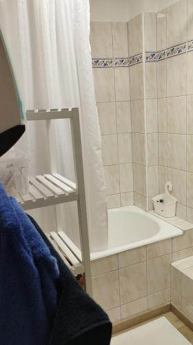 La salle de bains est pourvue d'une baignoire avec rideau de douche. dans l'établissement appartement cosy hyper centre de Cauterets, à Cauterets