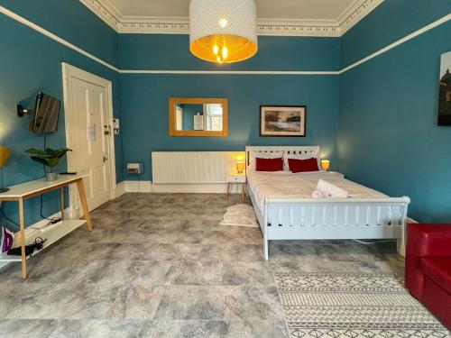 sypialnia z łóżkiem i niebieską ścianą w obiekcie Cozy Studio Apartment of Glasgows West End w Glasgow