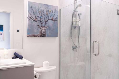 a bathroom with a shower with a painting of a deer at Bluebird Daze by Revelstoke Vacations in Revelstoke