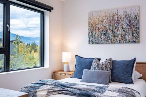 a bedroom with a bed and a large window at Bluebird Daze by Revelstoke Vacations in Revelstoke
