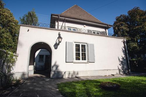 a white house with a door and an archway at Beautiful Villa in the Heart of Basel in Basel