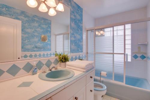 La salle de bains est pourvue d'un lavabo, de toilettes et d'une fenêtre. dans l'établissement Lakefront Algoma Home with Deck, Grill and Fireplace, à Algoma