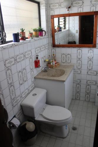 a bathroom with a toilet and a sink and a mirror at Casa de Tulia in Quito