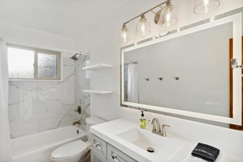 uma casa de banho branca com um lavatório e um espelho em Toltec Hideaway em Albuquerque
