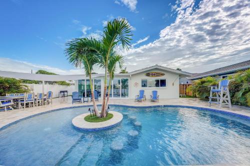 a swimming pool with a palm tree in front of a house at Fall Promo! Heated Pool, 6p Golf Cart, Kayak in Clearwater Beach
