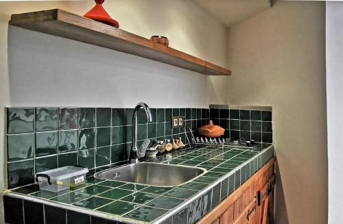 a kitchen with a sink and a green counter top at Aparthotel Dar Nowara Chaouen in Chefchaouen