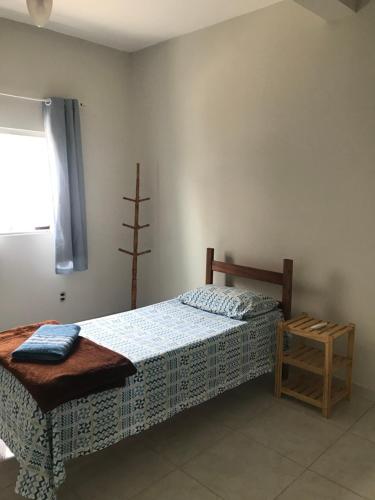 Schlafzimmer mit einem Bett und einem Fenster in der Unterkunft Pousada São Pedro in Aracruz