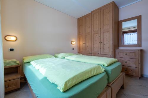 1 Schlafzimmer mit 2 Betten und Holzschränken in der Unterkunft Fior d'Alpe Apartment in Livigno