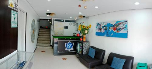 Una sala de estar con dos sillas y una chimenea. en Hotel Blue Zafiro, en Bogotá