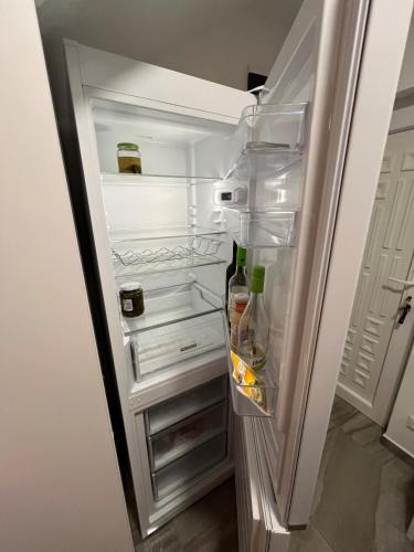 a refrigerator with its door open with drinks in it at Ciao Lilla Apartman in Keszthely