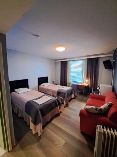 a hotel room with two beds and a couch at Hotelli Kärsämäki in Kärsämäki