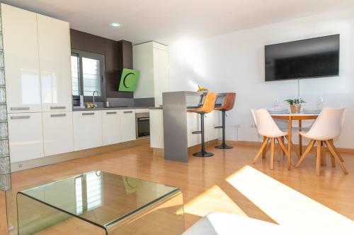 a kitchen with white cabinets and a table with chairs at Casa Luz de Rajamanta - Terraza vistas a 1º línea y Parking in Barbate