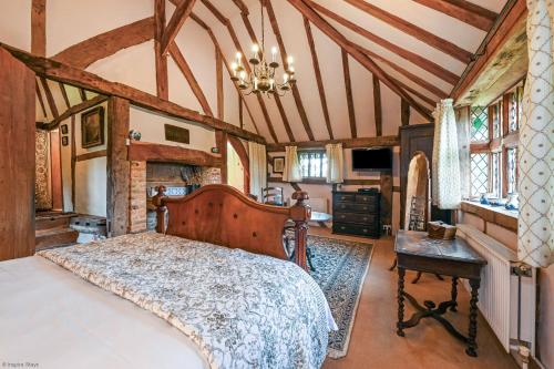 een slaapkamer met een groot bed en een kroonluchter bij Hell Fyre 1594 by Inspire Stays in Itchingfield