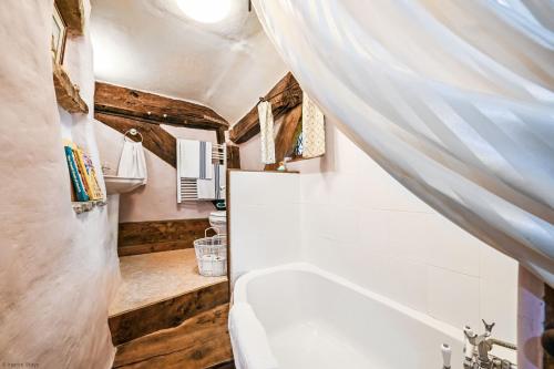 een badkamer met een wit bad en een wastafel bij Hell Fyre 1594 by Inspire Stays in Itchingfield