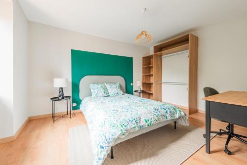 - une chambre avec un lit et un mur vert dans l'établissement La FORGE Appartement chaleureux et Grands espaces, à Molsheim