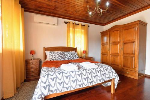a bedroom with a large bed and a wooden cabinet at Casa da Avó in Ponte de Lima