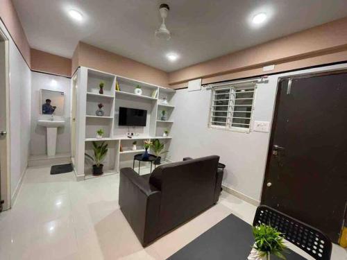 a living room with a couch and a sink and a television at Apricot: 1bhk Humble Abode in Botanical Gardens in Hyderabad