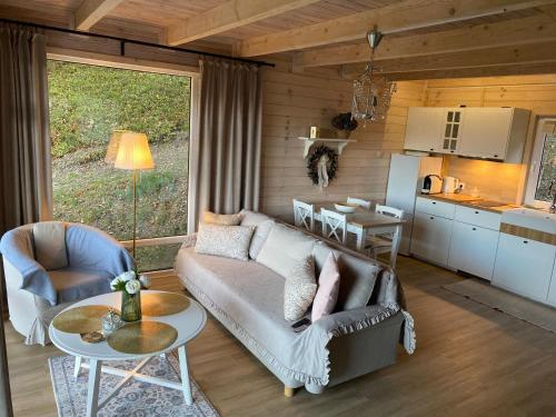 ein Wohnzimmer mit einem Sofa und einem Tisch sowie eine Küche in der Unterkunft Forest house in Targanice