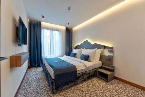 a hotel room with a bed and a large window at BuzzStays - Spa & Wellness Hotel - Privately Managed Apartments in Zlatibor