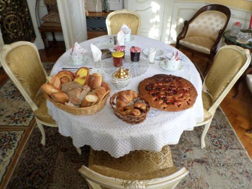 a white table with baskets of bread and pastries on it at Chambre individuelle à lit double dans une maison de Maître de 1904 in Haguenau