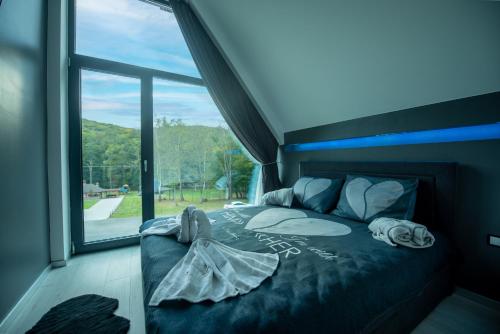 a bed in a room with a large window at Casa Negra in Brestovac