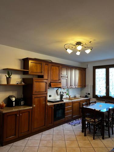 eine Küche mit Holzschränken und einem Tisch darin in der Unterkunft La Corte Sul Lago casa vacanze in Pisogne