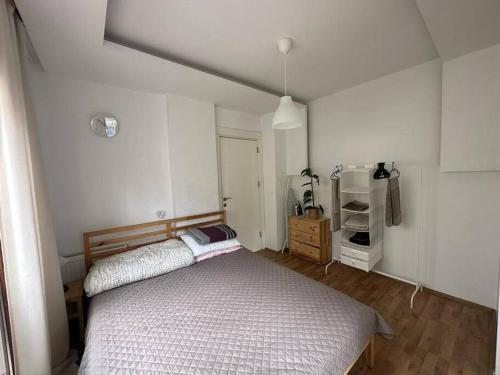 Dormitorio pequeño con cama y nevera en Deniz One Bedroom Appartment, en Mezitli