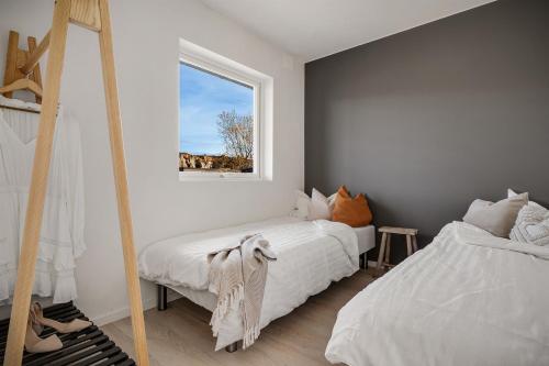 a bedroom with two beds and a window at Austefjorden hytte ved havet! in Forland