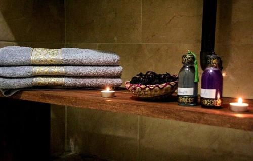 - une étagère dans une salle de bains pourvue de bougies et de serviettes dans l'établissement Riad Amazing, à Marrakech