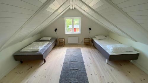 Schlafzimmer im Dachgeschoss mit 2 Betten und einem Fenster in der Unterkunft Charmig, nyrenoverat och fullt utrustad stuga. Anpassad för hundar, nära till naturen och havet. Gångavstånd till golfbana. in Kalmar