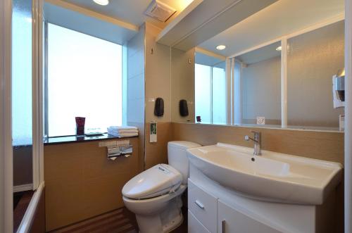 a bathroom with a sink and a toilet and a mirror at Yomi Hotel - ShuangLian MRT in Taipei