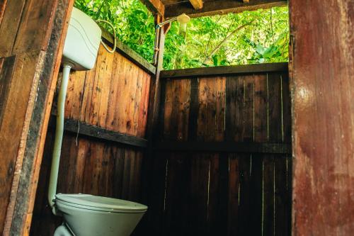 a bathroom with a toilet and a wooden fence at Fazenda Alegria Camping & Aventura in Rio de Janeiro