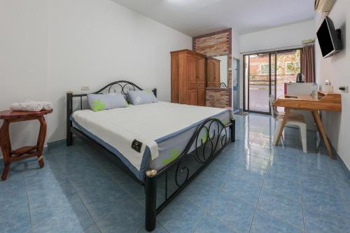 a bedroom with a bed and a table and a desk at View Mansion in Ban Bang Saen (1)