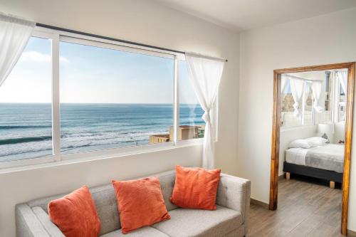 ein Wohnzimmer mit einem Sofa und Meerblick in der Unterkunft Ocean-VIEW Two Story Condo on the beach in Tijuana