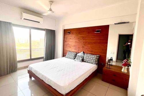 a bedroom with a bed and a large window at 1304 Premium and Fully Furnished Apartment in Ahmedabad